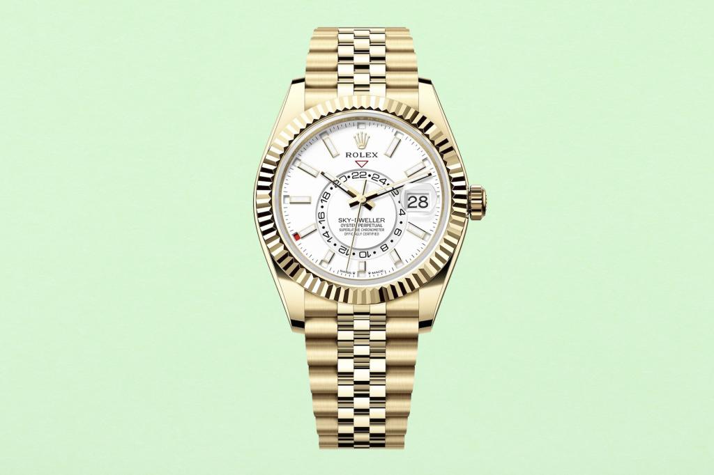 Gold watch with a white face on a fresh green paper texture background