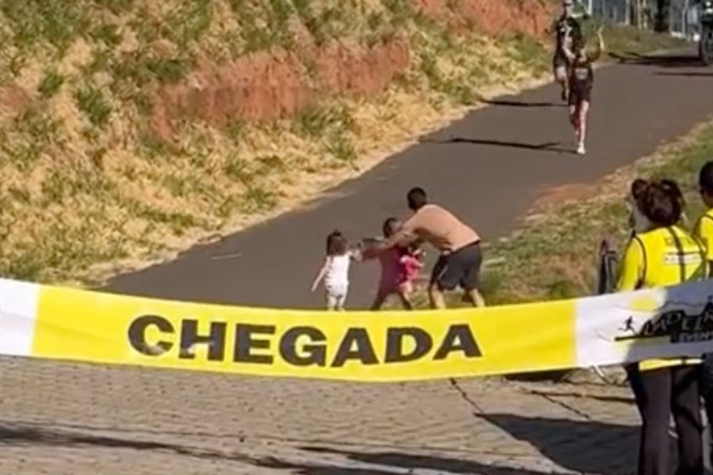 The dad appears to push his kids out to greet their mom mid-race.