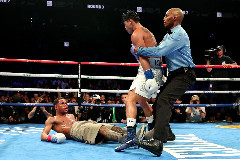 Ryan Garcia (white trunks) knocks down Devin Haney (gray trunks) during their WBC Super Lightweight title bout at Barclays Center on April 20, 2024 in New York City.  