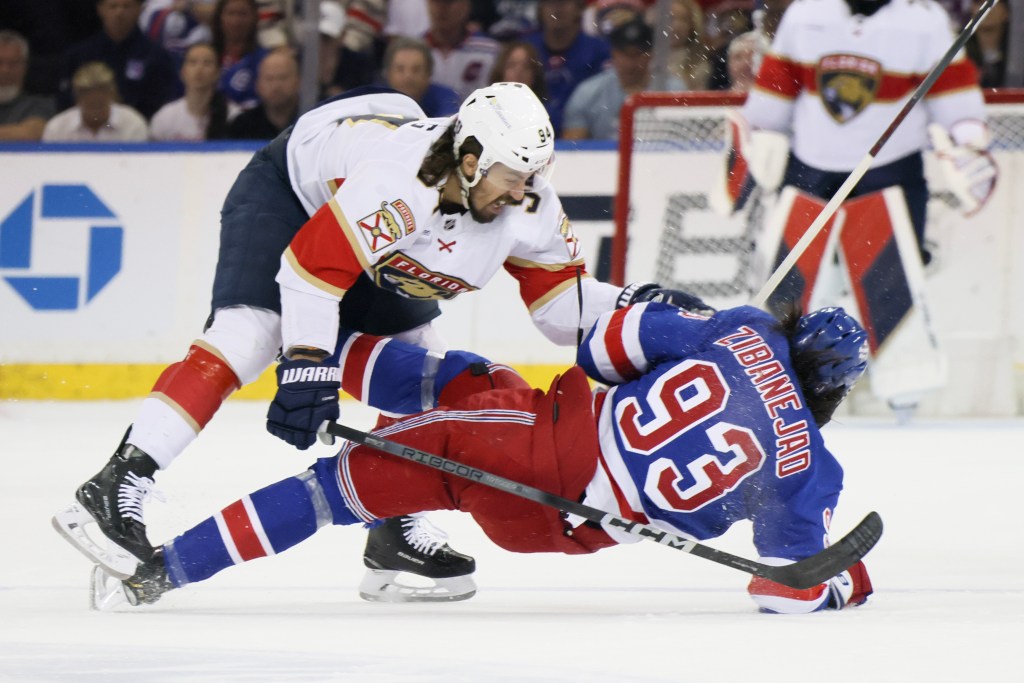 Ryan Lomberg #94 of the Florida Panthers checks Mika Zibanejad #93 of the New York Rangers during the first period