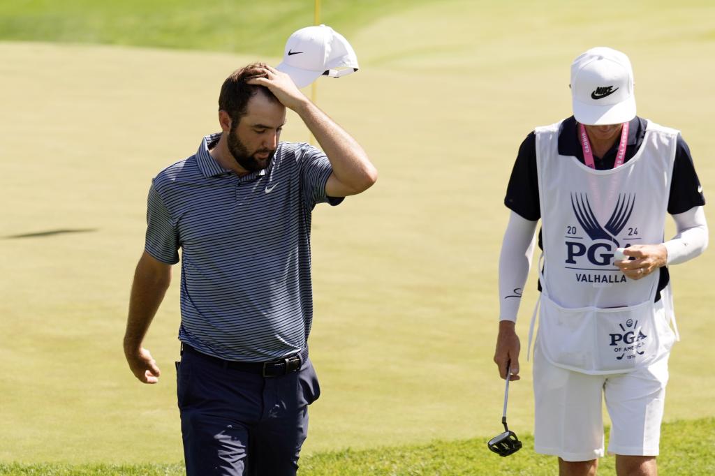 Scottie Scheffler and his caddie walk off the 18th green after the final round of the PGA Championship on Sunday.