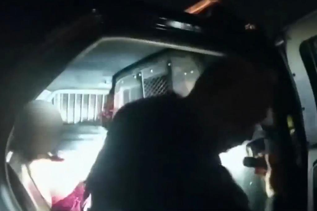 Officer turning off his bodycam in police car with female detainee on a residential street at night