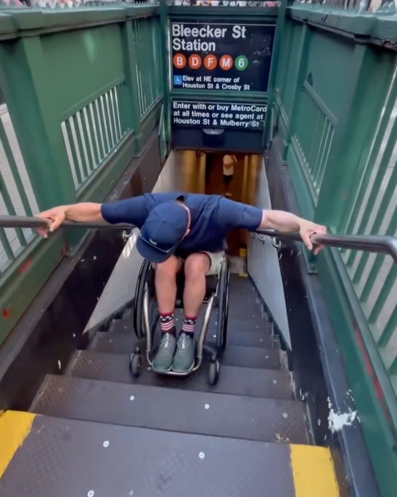 Trevor Kennison in a wheelchair rolling backwards into the Bleeker Street subway station