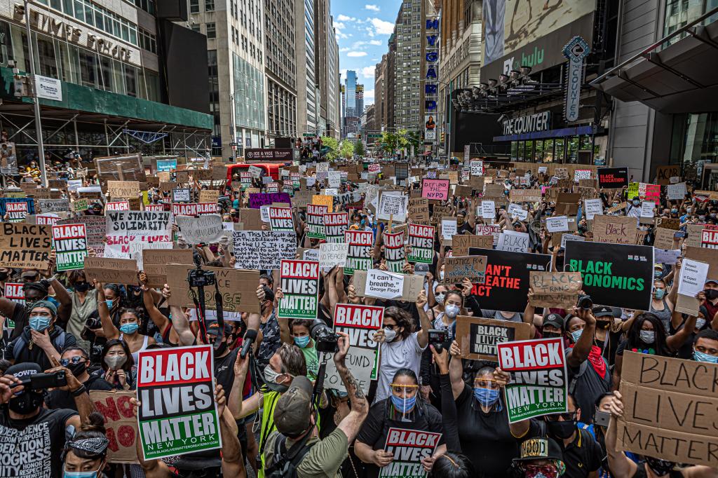 Group of people marching and holding "Black Lives Matter" signs