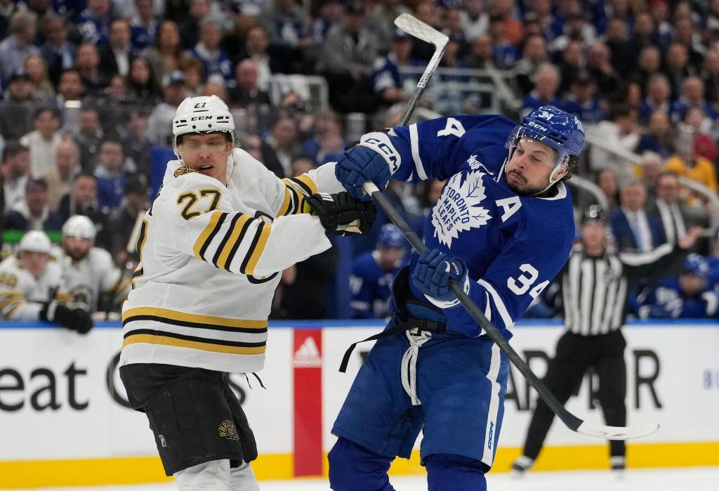 Toronto Maple Leafs forward Auston Matthews and Boston Bruins defenseman Hampus Lindholm battling for position during an NHL game at Scotiabank Arena