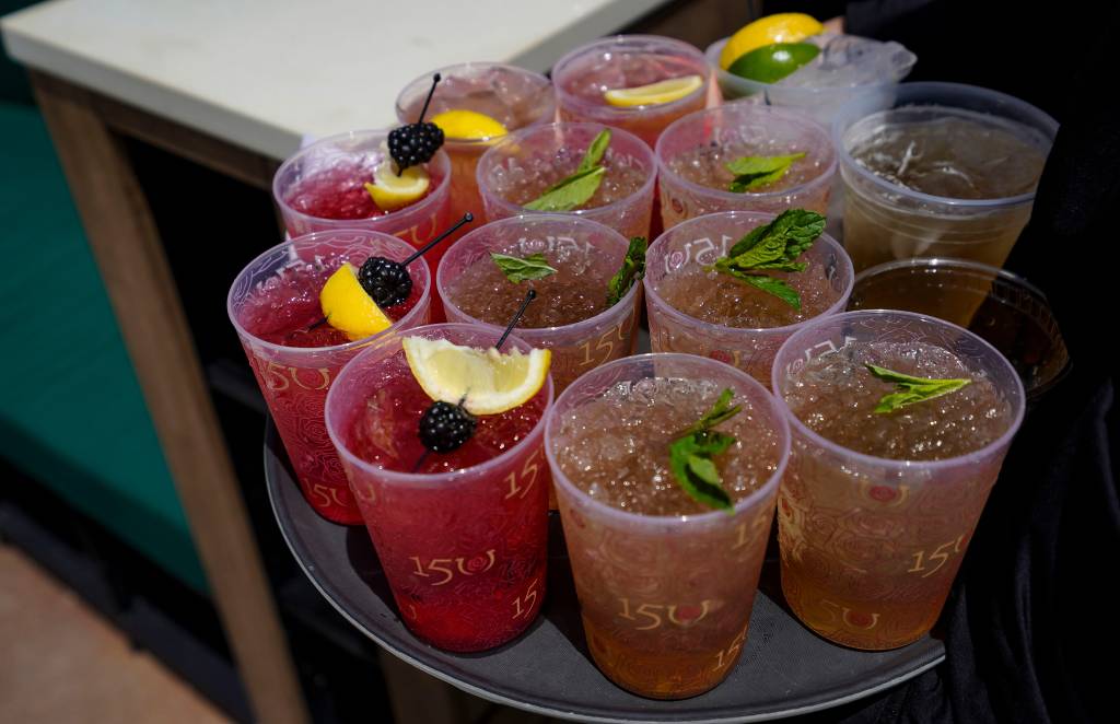 A tray of mint julep drinks with fruit garnish at Churchill Downs