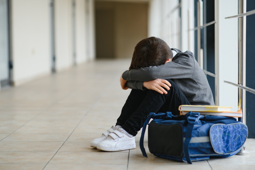 Upset boy sitting at school.