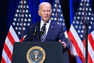 US President Joe Biden speaking at a podium with microphones and flags at the National Museum of African American History and Culture