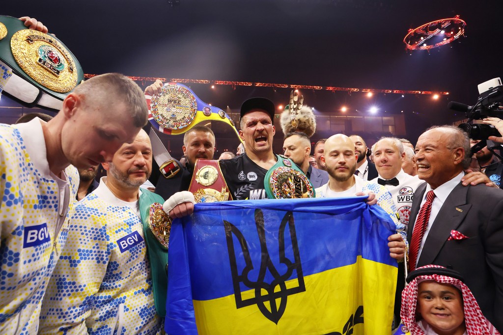 Oleksandr Usyk celebrates with Ukraine's flag after defeating Tyson Fury.