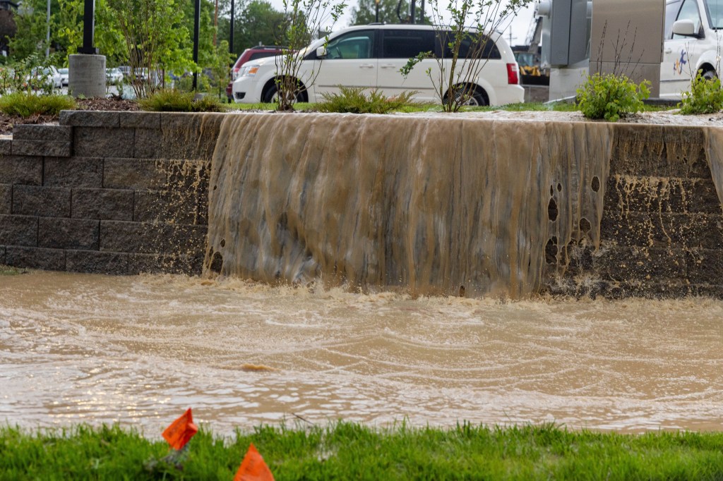 Water pours out of a parking lot following a storm in Omaha, Nebraska on May 21, 2024.