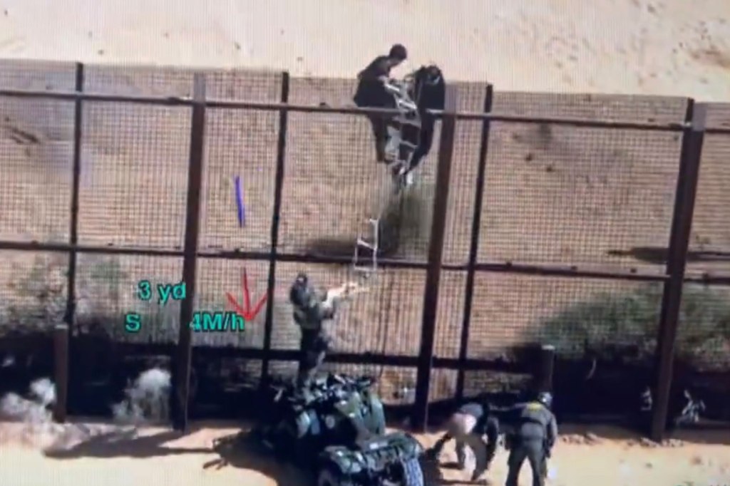 Two migrants battled with US Border Patrol over a rope ladder. 