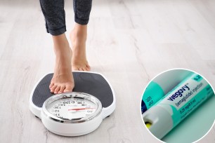 Woman measuring her weight using scales on floor