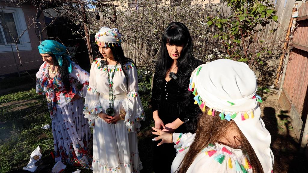 Brocarde, a 40-year old woman wearing a white dress, learning witchcraft from a group of women in Romania, in order to protect herself from her ghost ex-husband