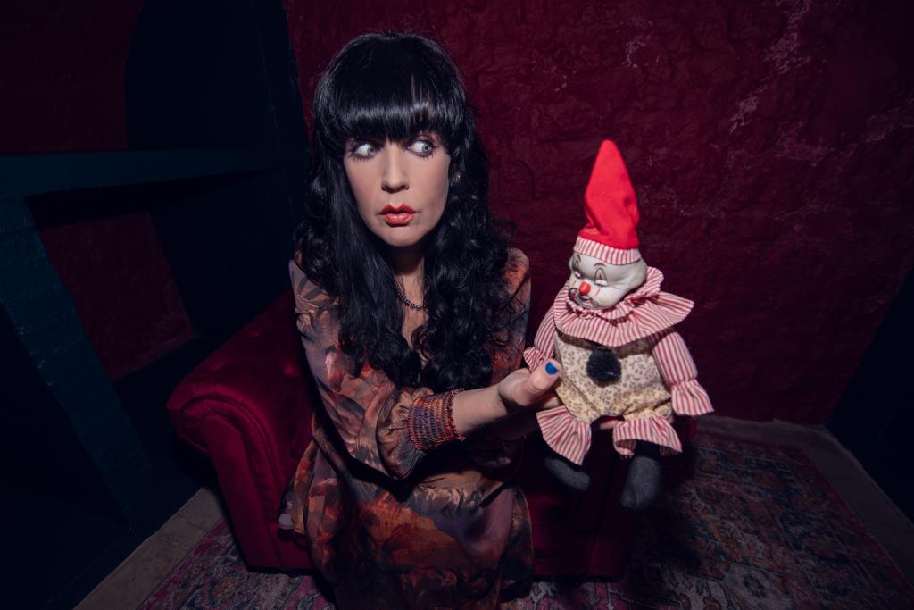 Woman named Brocarde holding a clown doll at The Clown Motel in Nevada, USA