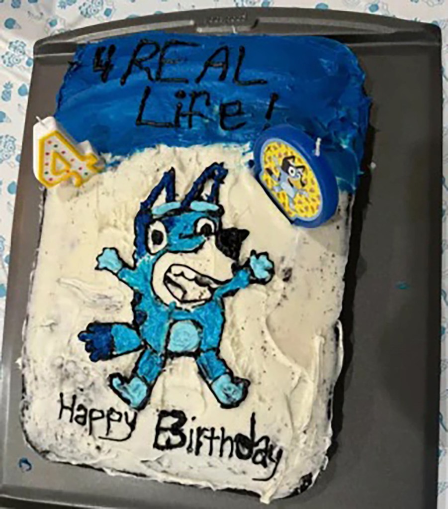 A homemade Bluey-themed birthday cake with a cartoon character on it, made by a mum for her daughter's 4th birthday