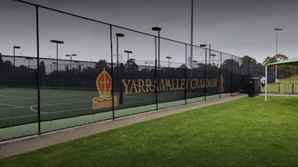 Yarra Valley Grammar School with a tennis court, grass, and surrounding fence