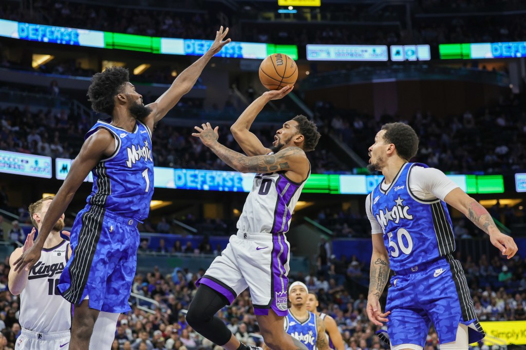 Sacramento Kings guard Malik Monk (0) shoots the ball against Orlando Magic forward Jonathan Isaac (1) during the second quarter at KIA Center.