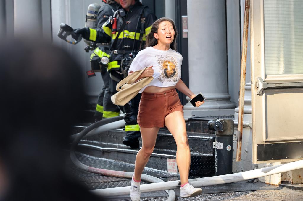 A woman runs from the building during an early morning fire on Broome Street in Soho.