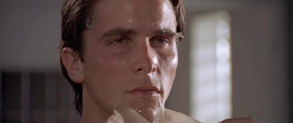 Christian Bale as Patrick Bateman in the film 'American Psycho', during his morning routine with a wet face.