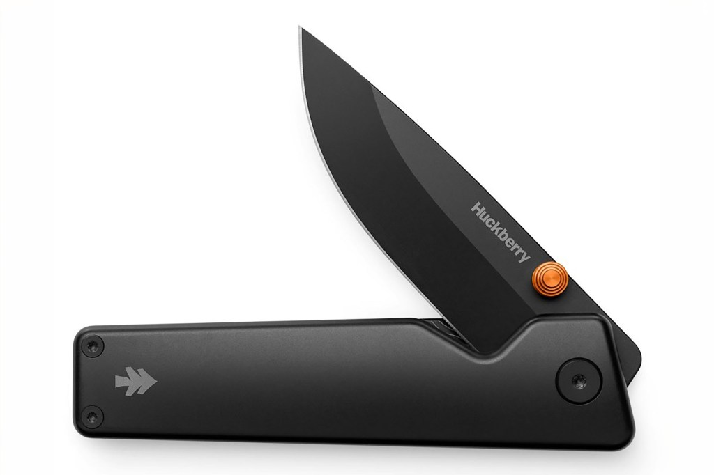 A black pocket knife with an orange button