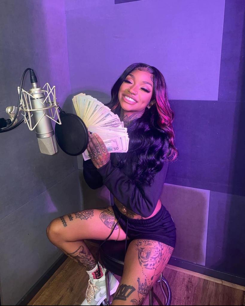 Female rapper Enchanting holding money and a microphone, pursuing her music career