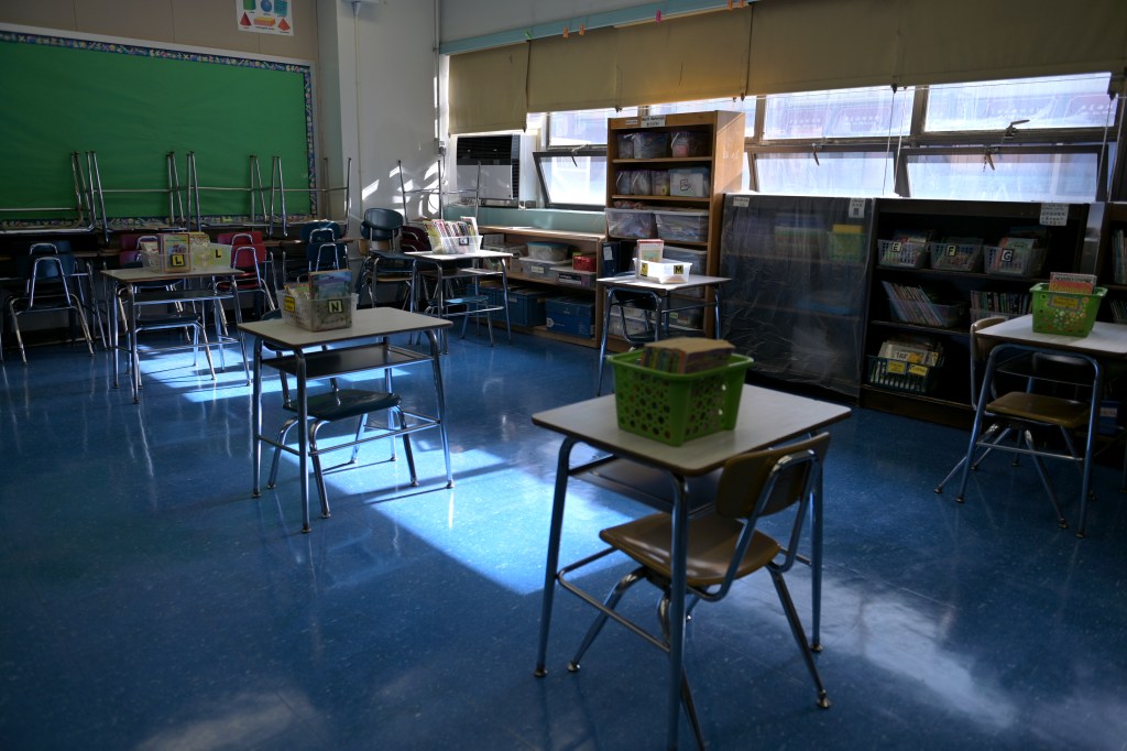 A classroom is empty with the lights off on what would otherwise be a blended learning school day on November 19, 2020 at Yung Wing School P.S. 124 in New York City.