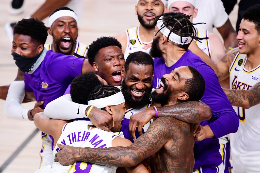 LeBron James and Quinn Cook of the Los Angeles Lakers celebrating with teammates, including J.R. Smith, Kentavious Caldwell-Pope, Jared Dudley, after winning the 2020 NBA Championship, Game Six