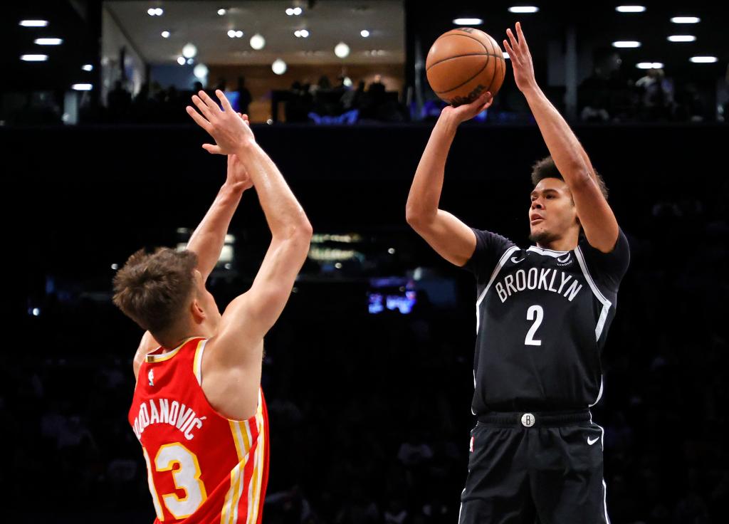 Cameron Johnson of the Brooklyn Nets attempting a shot while Bogdan Bogdanovic of the Atlanta Hawks jumps to defend during a game at Barclays Center