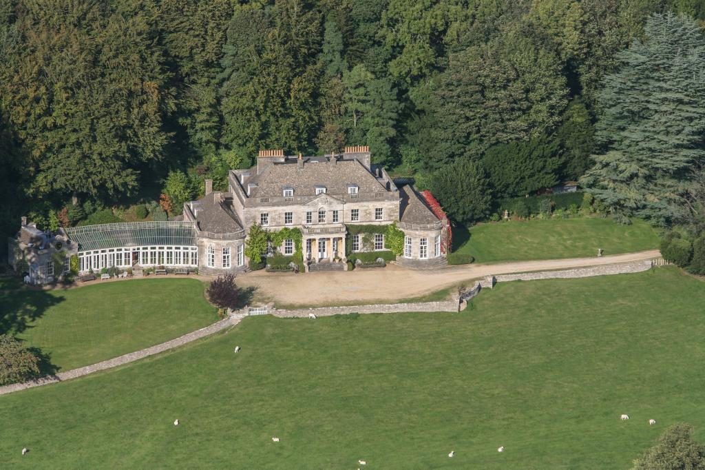Aerial view of Gatcombe Park, the 18th-century country residence of Anne, The Princess Royal, featuring a large stone house with extensive lawn and trees