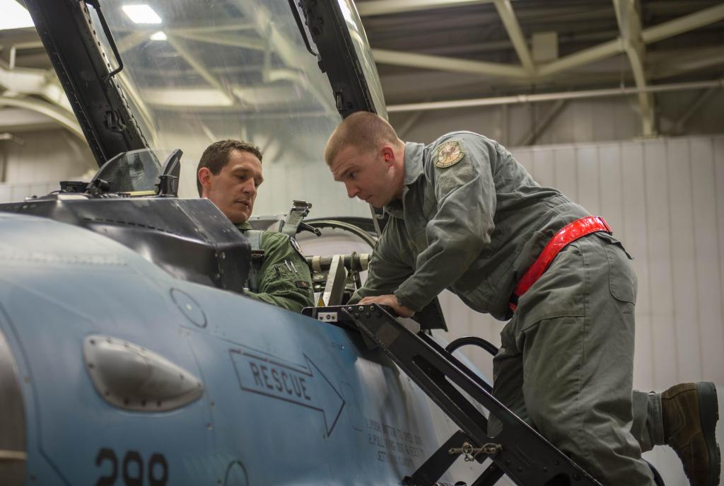 Air Force Staff Sgt. Robert Knickle, right, helps Lt. Col. Mark Sletten into an F-16 Fighting Falcon fighter aircraft on Eielson Air Force Base, Alaska, Dec. 7, 2015.