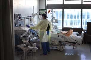 Respiratory Therapist Nirali Patel works with a COVID-19 patient in the ICU at Rush University Medial Center on January 31, 2022 in Chicago, Illinois.