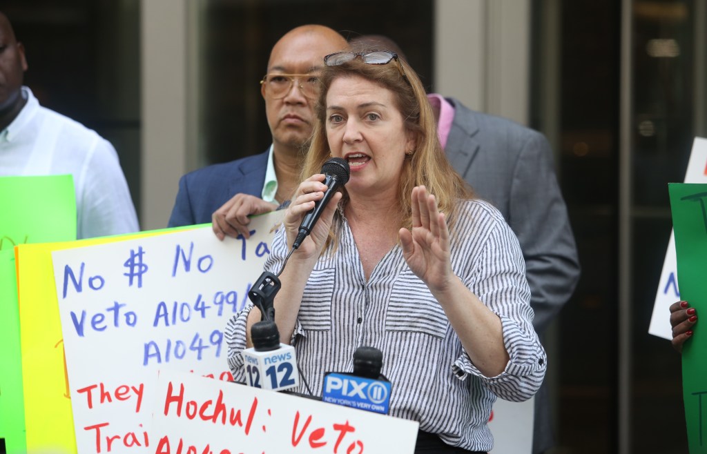 Maud Maron, Candidate for City Council District 1, speaking into a microphone during a protest outside NY State Governor Kathy Hochul's Manhattan office on June 10, 2022