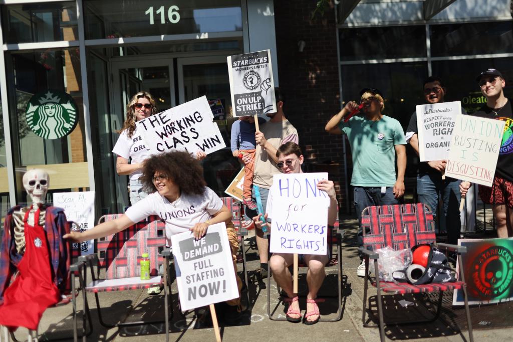 Group of people holding protest signs in front of a Starbucks store in Greektown, Chicago, during an event organized by the Starbucks union over Pride decorations ban