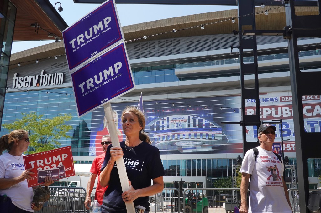 Supporters of former President Donald Trump carrying signs around the Fiserv Forum in Milwaukee, Wisconsin prior to the first GOP debate