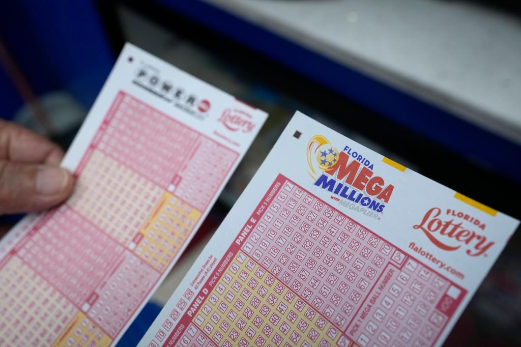 A lottery player holds forms to pick numbers for the Powerball and Mega Millions lotteries as he buys tickets, Monday, Aug. 7, 2023.