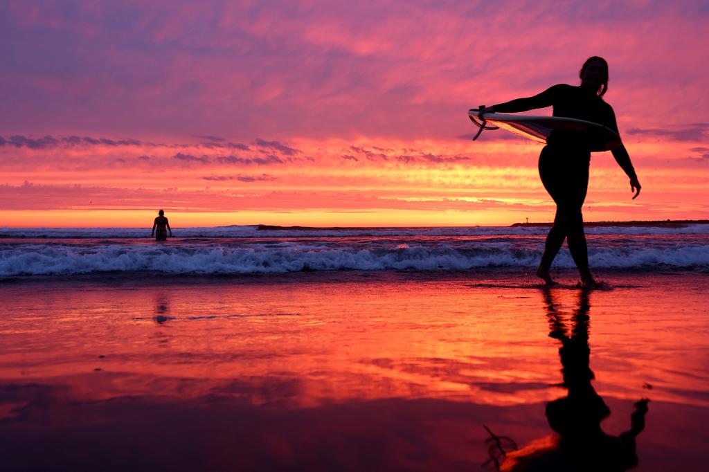 people in water at sunset