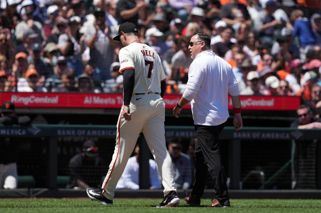 San Francisco Giants starting pitcher Blake Snell (7) walks off of the field with athletic trainer Dave Groeschner (right) during the fifth inning against the New York Yankees at Oracle Park.