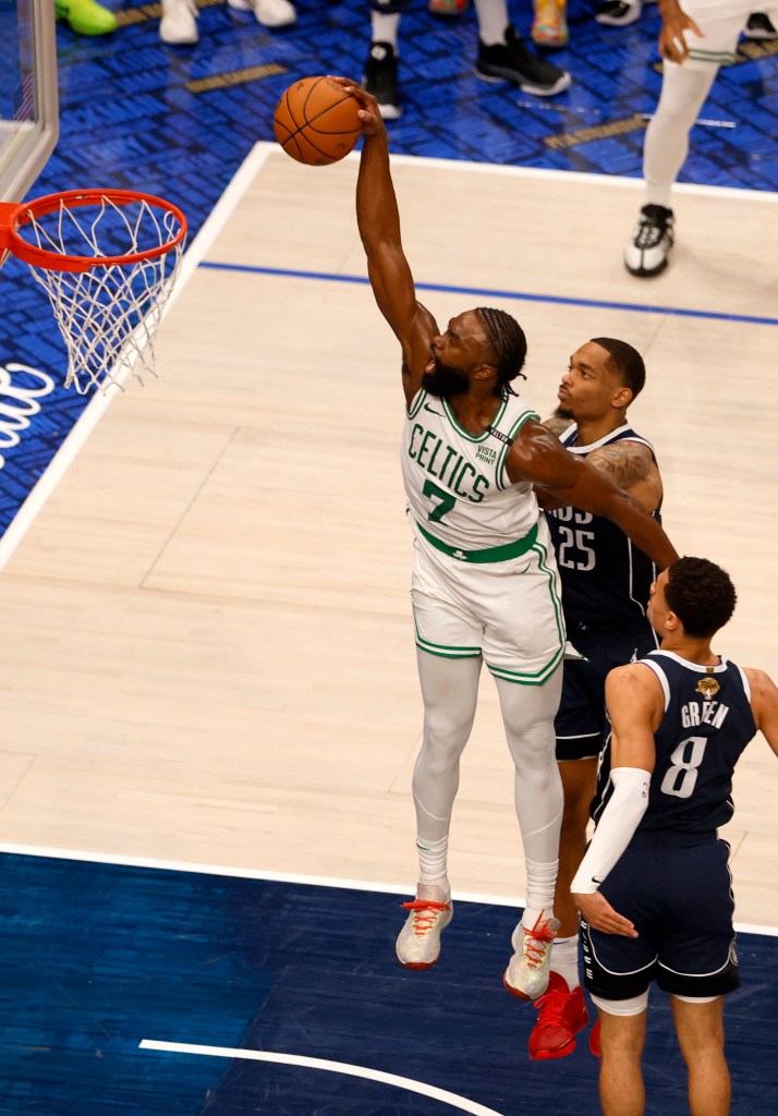 Boston Celtics guard Jaylen Brown (7) dunks against Dallas Mavericks forward P.J. Washington (25) and guard Josh Green (8) during the third quarter in game three of the 2024 NBA Finals at American Airlines Center. 