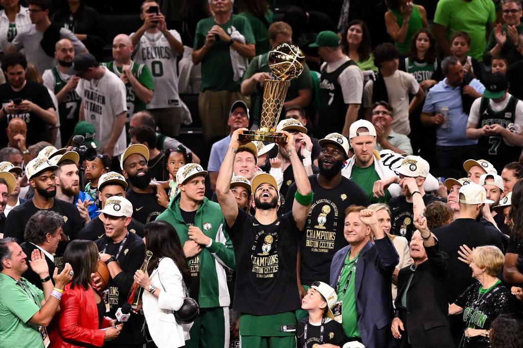 Boston Celtics forward Jayson Tatum holding up the Larry O'Brien Championship Trophy after winning the 2024 NBA Finals against the Dallas Mavericks