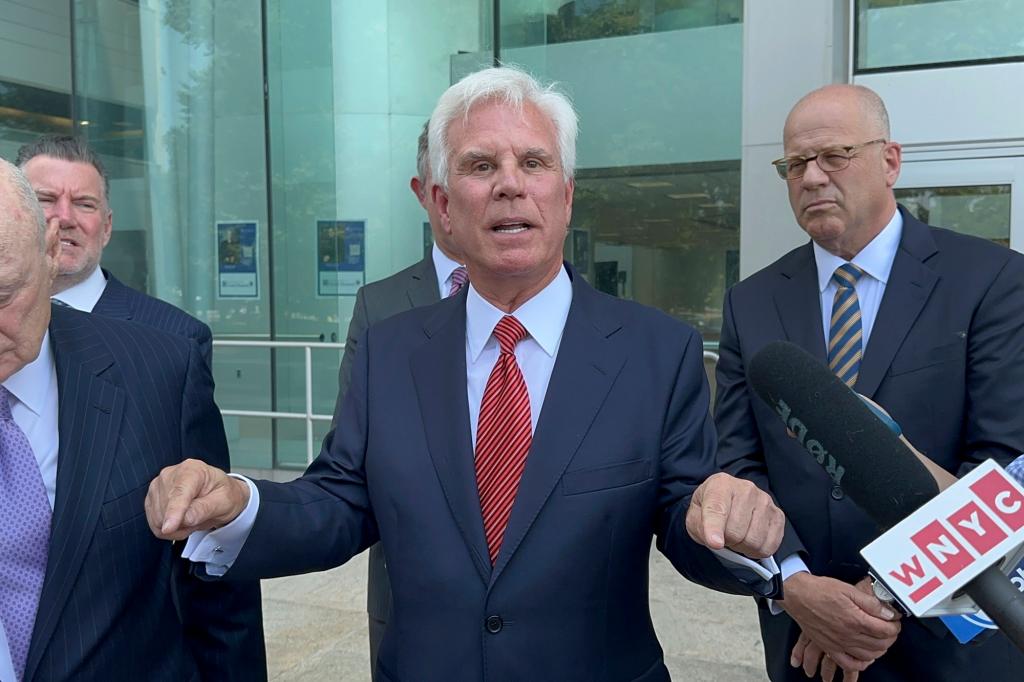 George Norcross III, influential Democratic power broker, speaking outside the justice complex in Trenton, N.J., surrounded by a group of men in suits, after being charged with racketeering