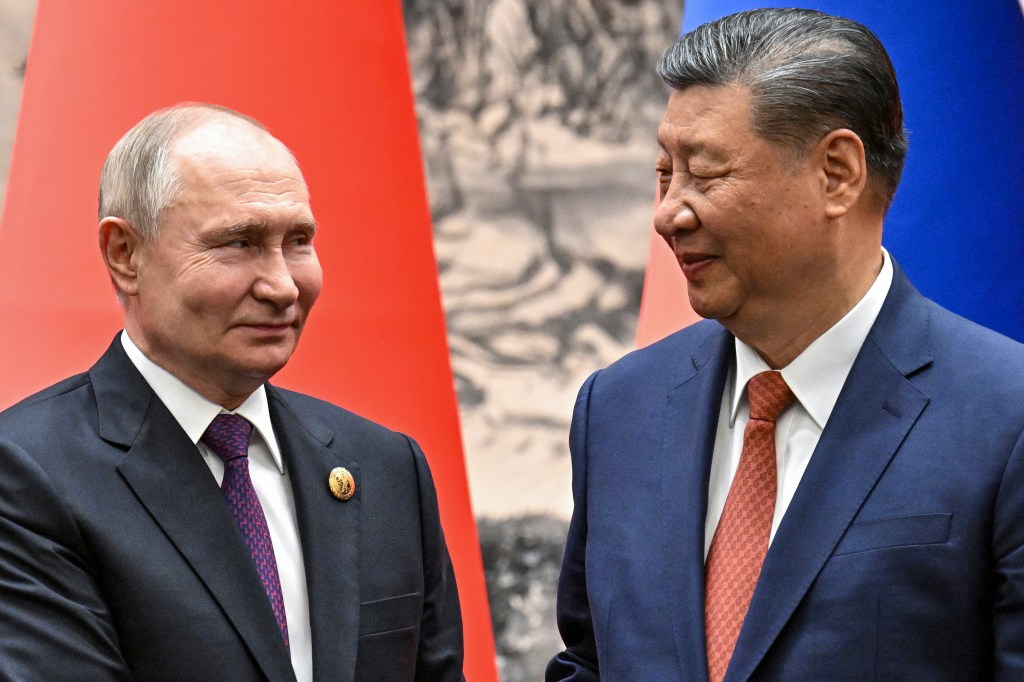 Vladimir Putin and Xi Jinping smiling at each other.