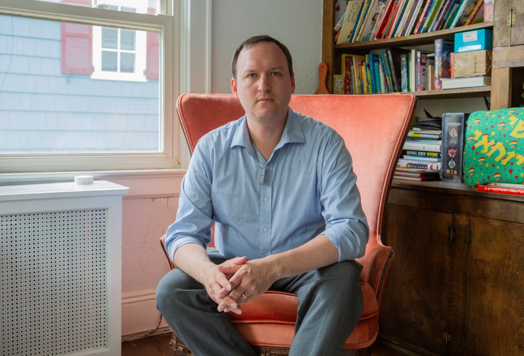 Josh Savitt sitting in a chair, reflecting on the protests he experienced at the Nova Exhibit in 2024 and subsequent harassment on the subway