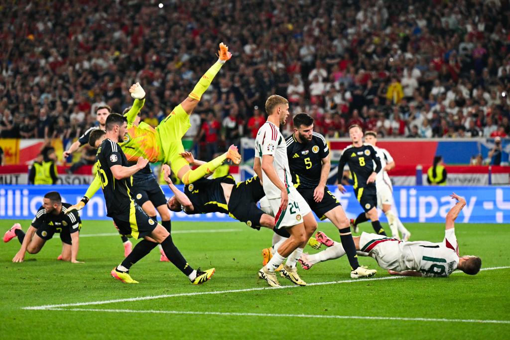 Hungary's forward Barnabas Varga falling after colliding with Scotland's goalkeeper Angus Gunn during a Euro 2024 football match