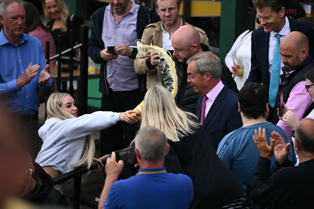 A woman threw a milkshake at British right-wing politician Nigel Farage on Tuesday.