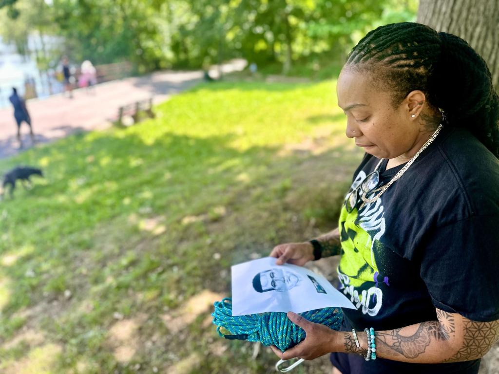 Queens mom examines rapists' wanted poster.