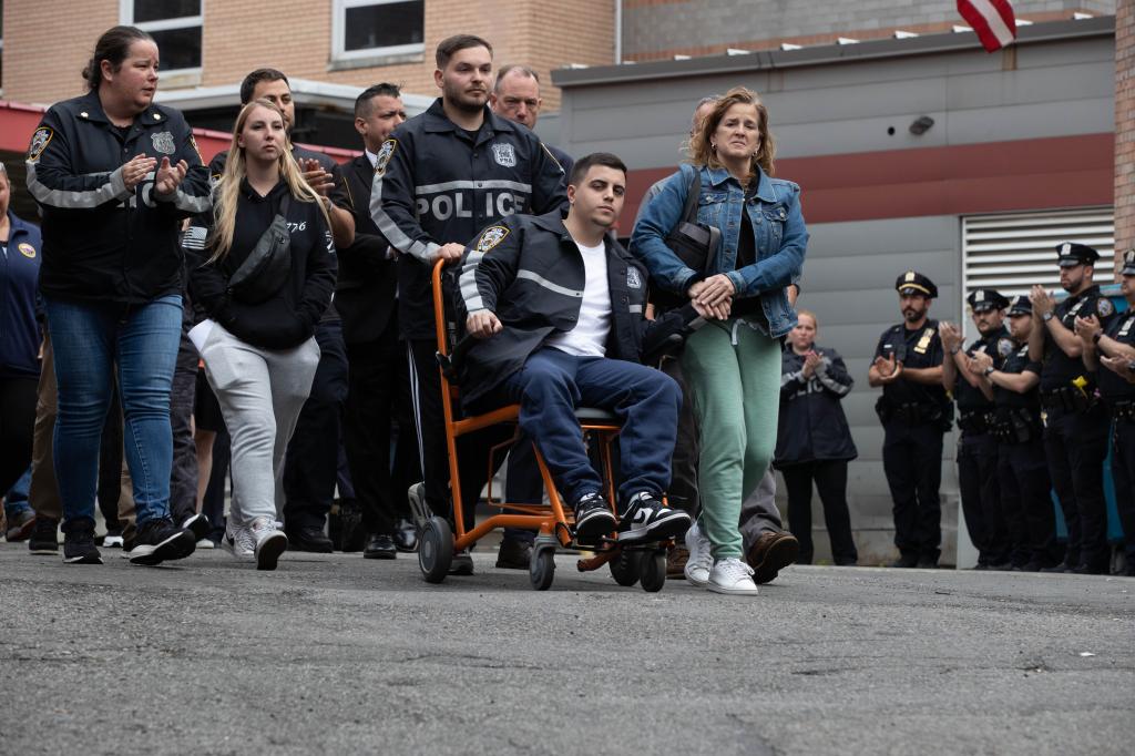 NYPD officers Christopher Abreu and Richard Yarusso, center, leave Elmhurst Hospital surrounded by supporters during a "guard of honor" service.