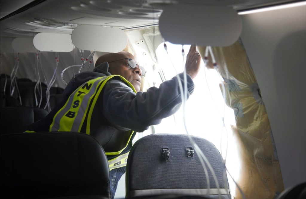 NTSB Investigator John Lovell examining the fuselage plug area of Alaska Airlines Flight 1282, a Boeing 737 Max 9, that made an emergency landing in Portland, Oregon