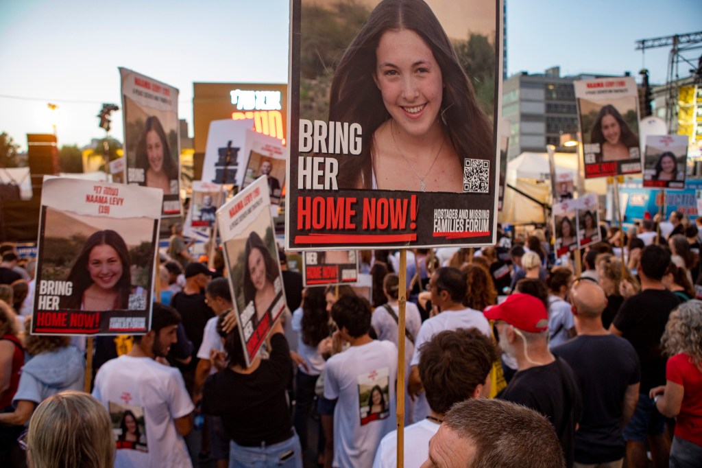 sraelis gather in the Hostages Square, carrying posters of Israelis being held hostage by Hamas.