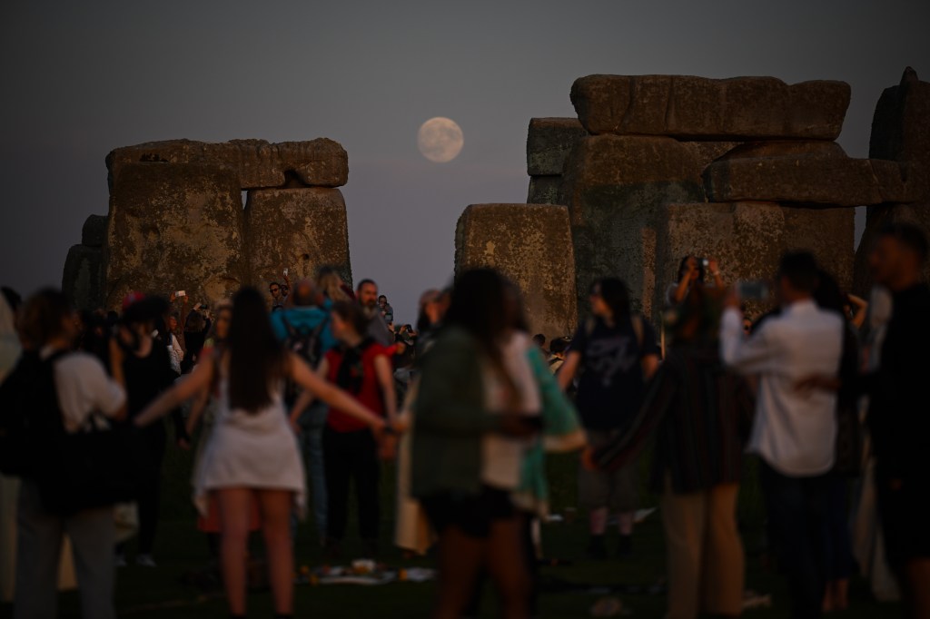 WILTSHIRE, ENGLAND - JUNE 20: The moon rises behind Stonehenge, on June 20, 2024 in Wiltshire, England. On the longest day of the year in the Northern Hemisphere, the sun rises in perfect alignment with the Heel Stone and Altar Stone of Stonehenge's 5000-year-old circle. This alignment shows the ancient builders' understanding of the solar calendar and suggests Stonehenge may have served as a calendar or temple for important dates and events - a tradition that continues to be marked each year. (Photo by Finnbarr Webster/Getty Images)
