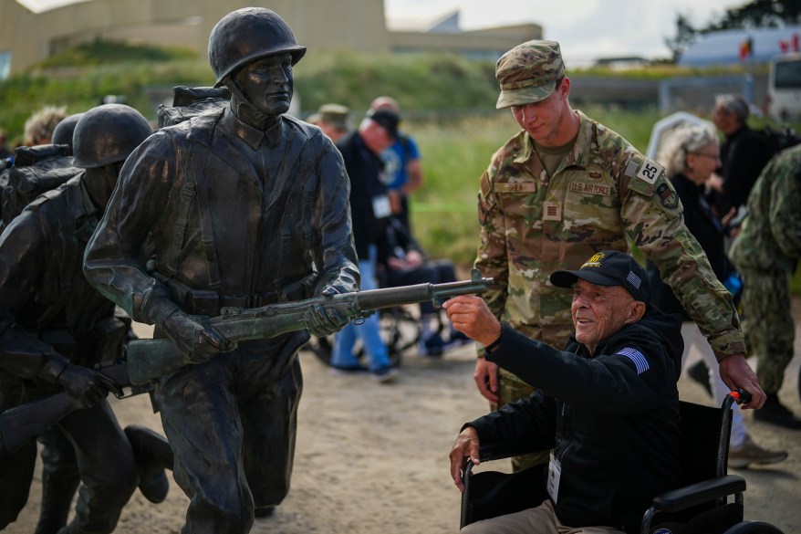 American World War II veteran Anthony Pagano, 97, touches a sculpture on Utah Beach, Normandy.